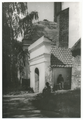 Kircheneingang mit Gutsmausoleum im Hintergrund mit Kuppel