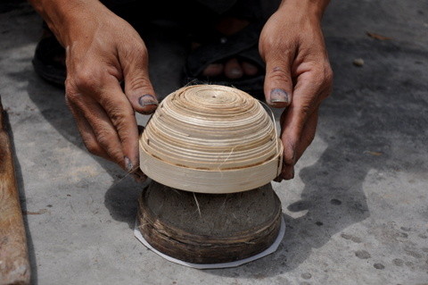 Cette structure étant encore souple, l'artisan la façonne à la main et lui donne son volume, avant de l'adapter sur un moule en pierre pour en régulariser les contours et obtenir la forme finale.