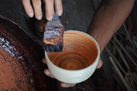 L'artisan applique la colle sur la pièce pour en fixer la forme.