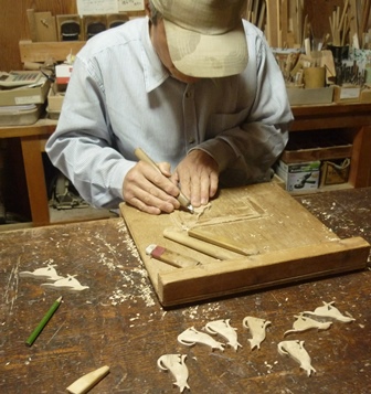 オリーブ材でイヌのブローチ手彫り中