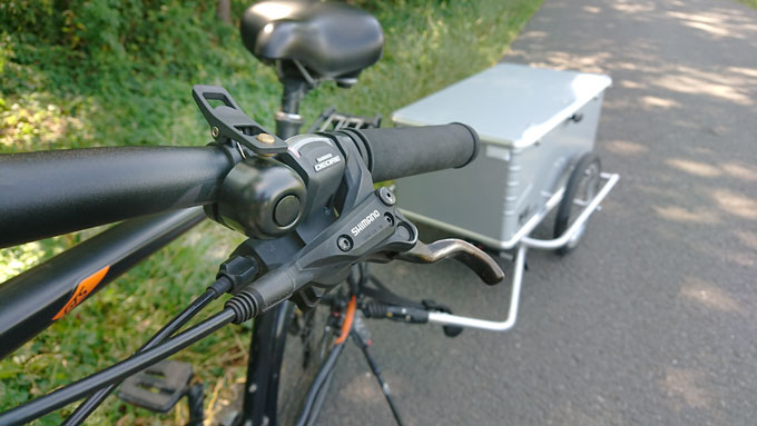 Die kleine laute schwarze Fahrradklingel an einem schwarzen Lenker montiert.
