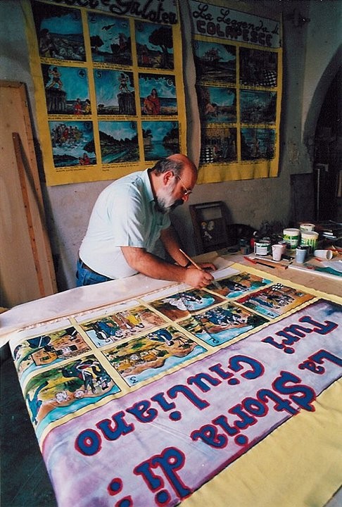 MENTYRE DIPINGE I CARTELLONI NEL SUO LABORATORIO