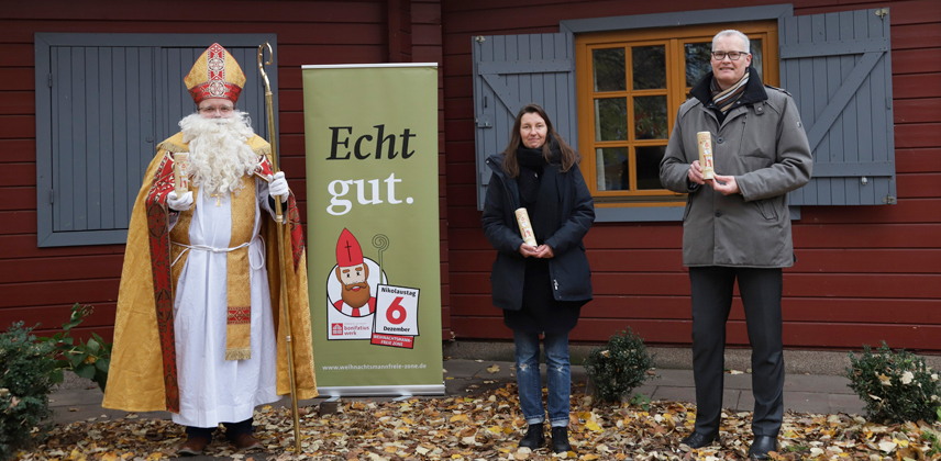 Bischof Nikolaus und der Vorsitzende des Diözesan-Bonifatiuswerkes in Hamburg, Michael Focke, überreichten die Schoko-Nikoläuse an Christiane Hartkopf von der Alimaus. (Foto: Valerie Wagner)