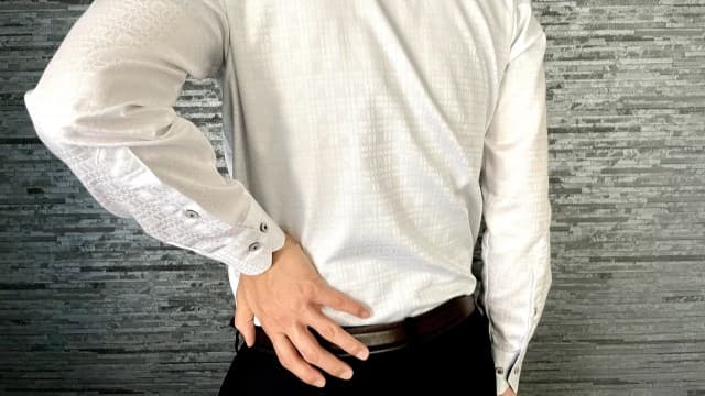 腰痛で腰をおさえてる男性