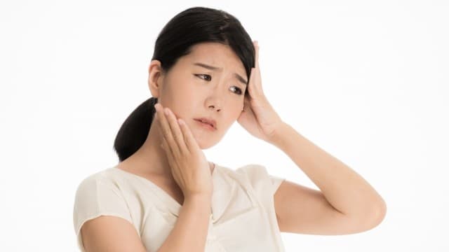 食いしばりによる顎の不調と頭痛に悩む女性
