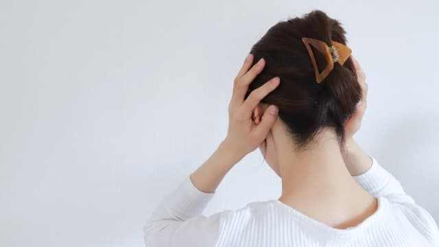 自律神経の乱れによるストレスで頭を抱える女性