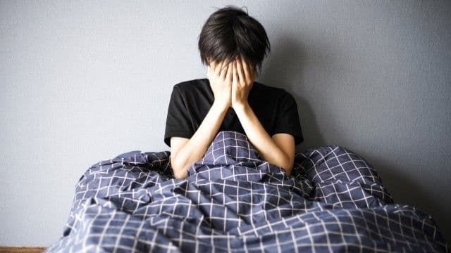 寝付きが悪く悩む男性