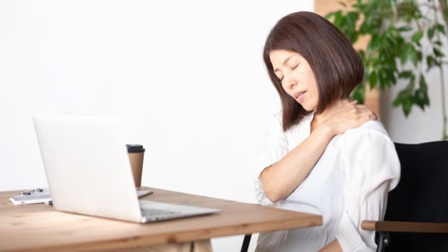 デスクワークで首こりと肩こりを感じている女性