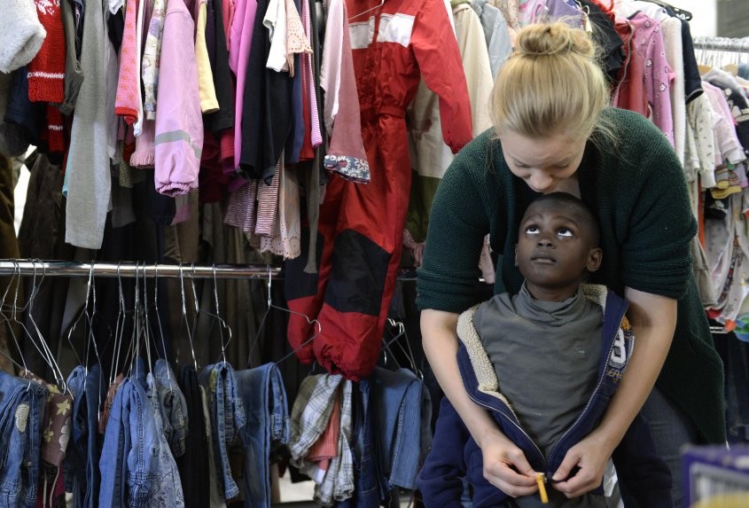 Mujer Alemana ayuda a probarse ropa a refugiado sirio