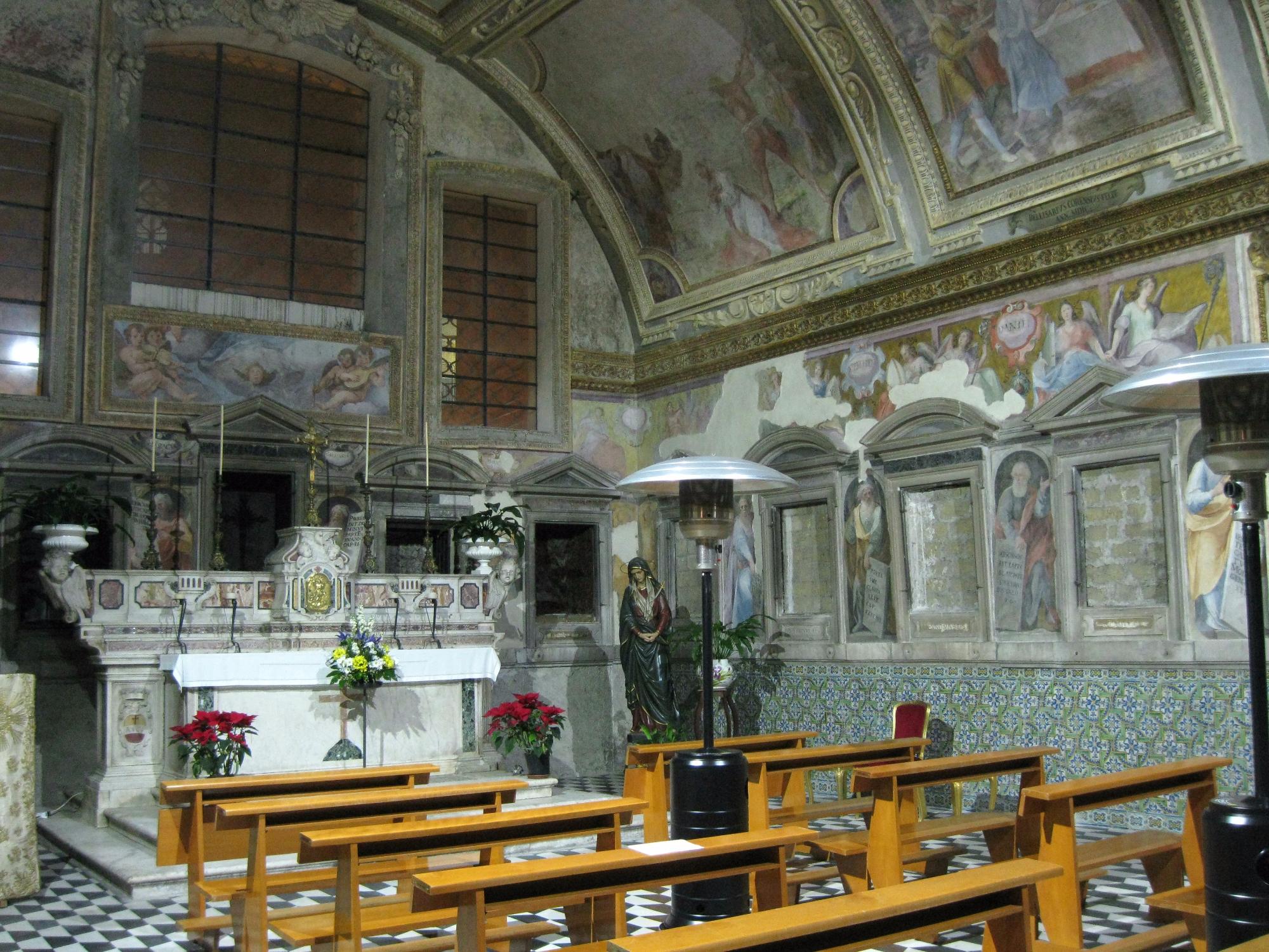 La parete prospiciente, con le nicchie ancora murate e l'Altare maggiore, che attualmente custodisce le reliquie dei Martiri; l'affresco in alto, dipinto dal CORENZIO e aiuti, rappresenta il "Martirio di S. Orsola"