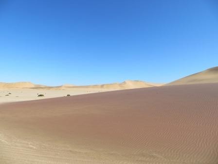 Mineralien lassen den Sand rot und schwarz schimmern
