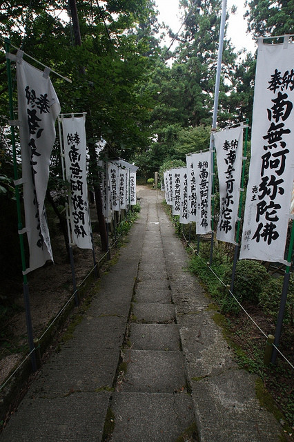 This is the entrance of Honen-do Temple in Mt. Hiei, where Honen Shonin (1133-1212) received Tokudo-Ordination.  The white banners both sides are called "Nobori" in Japanese.   It says, "Offering of Namu Amida Butsu" and donor's name is written.