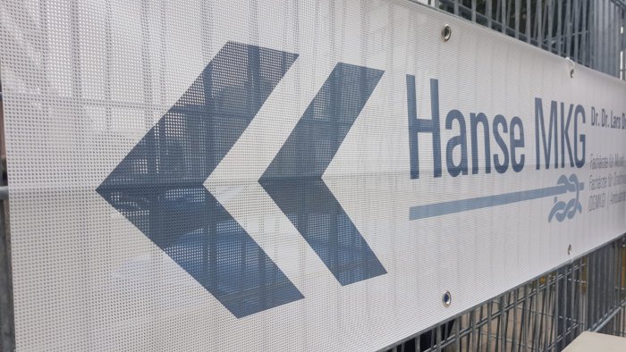 Nahaufnahme von Mesh-Banner Material mit winddurchlässiger Struktur und Ösen