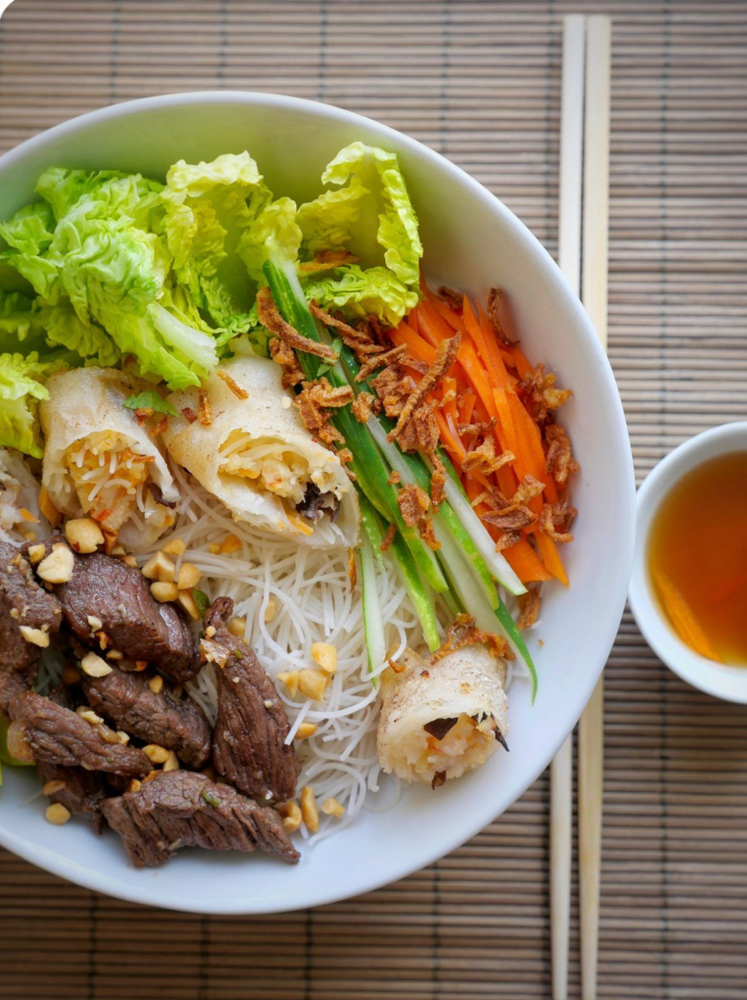 Bún Panda | Ein Geschmackserlebnis aus Vietnam | Geniessen Sie unser beliebtes Gericht Bún Panda: zarte Reisnudeln mit saftig mariniertem Rindfleisch, serviert mit knackigem Gemüse und aromatischen Kräutern. Dazu reichen wir knusprige vietnamesische Frühlingsrollen mit zartem Poulet, fein abgeschmeckt mit traditioneller Fischsauce. Frisch, leicht und voller Geschmack.