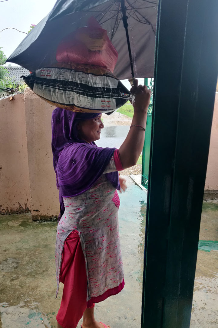 Frau in Nepalganj trägt das von uns erhaltene Lebensmittelpaket nach Hause