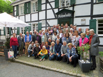 Chorgruppe vor einem Fachwerkhaus