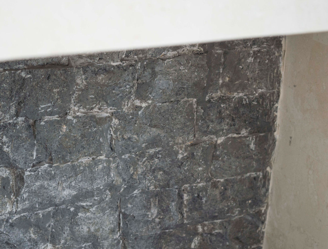 rustikale Rückwand aus grauem Fossilstein