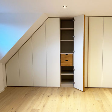 Ein großer Einbauschrank im Schlafzimmer, Türen mit TipOn und Stangengriff.