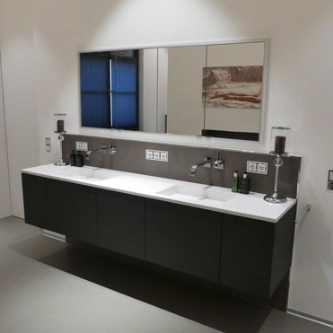 Der Unterschrank hat dunkle Fronten, der Waschtisch in Corian mit Doppelwaschbecken