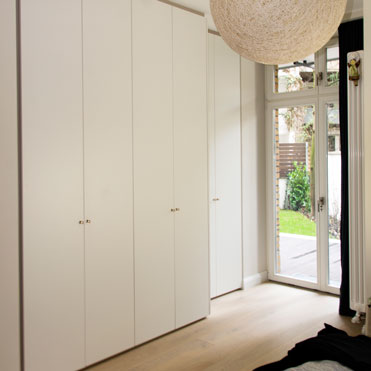 Ein Schlafzimmerschrank in Weiß, Griffe in Leder
