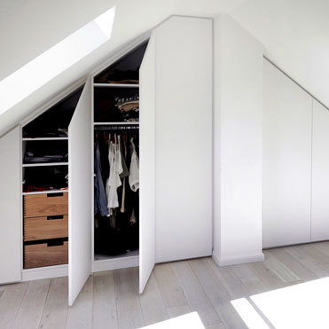 Ein Einbauschrank in der Dachschräge mit Schubkästen in Eiche, eingebaut in Düsseldorf