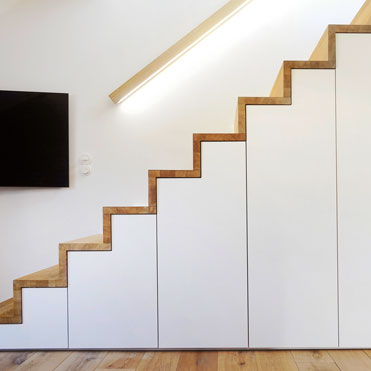 Schrank unter der Treppe, hier wurden die Türen exakt dem Verlauf der Treppe angepasst 