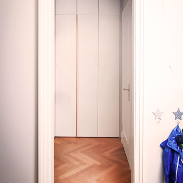 Eine Garderobe in Düsseldorf für Gäste und Familie, die Oberfläche in Weiß, passend zu den Zimmertüren