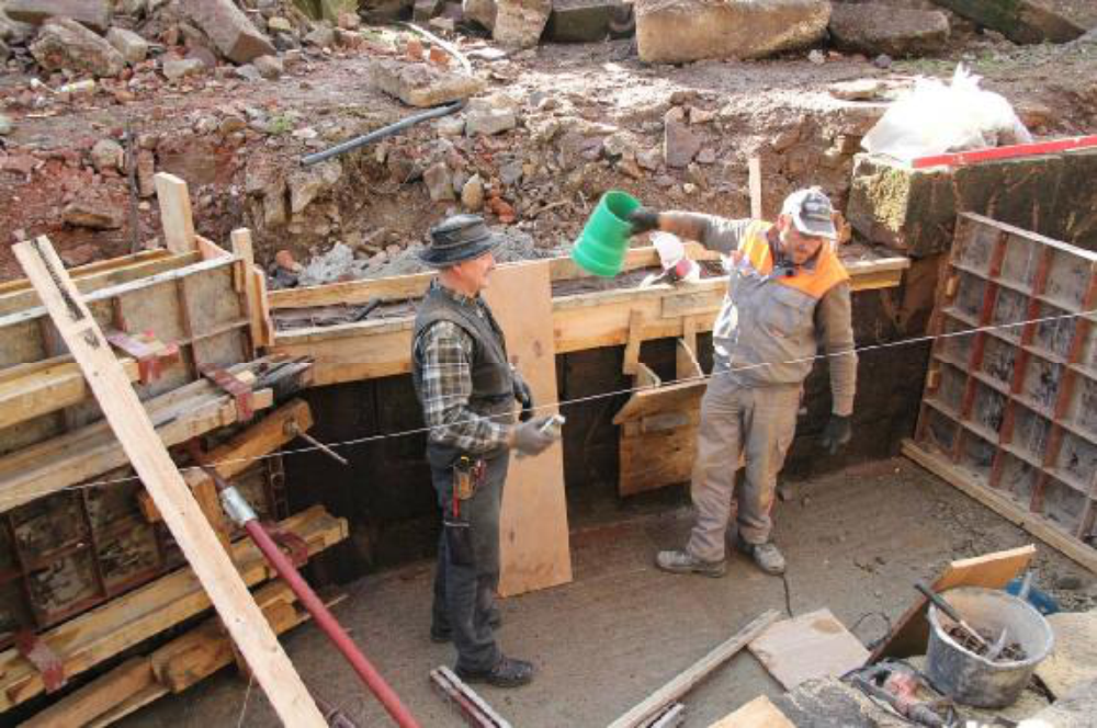 Das Aalrohr muss vor dem betonieren montiert sein. Kleine Einfülltrichter helfen den Beton auch hinter die verbliebenen Sandsteine zu bringen.