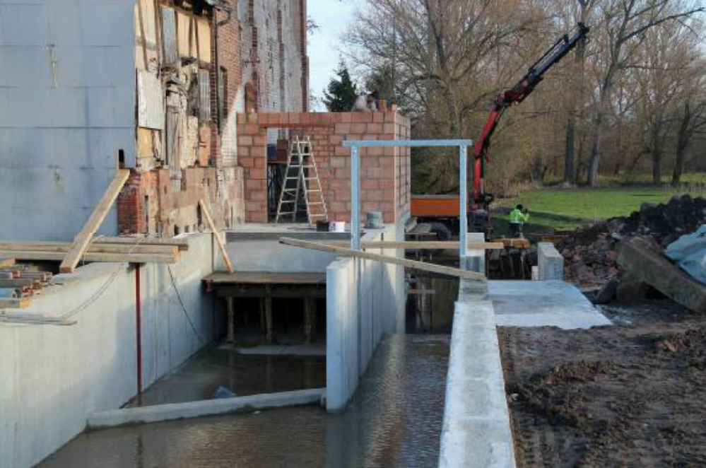 Das erste Wasser fließt durch den Leerschuss. Vor dem Einströmkanal schräg angeordnet, die Geschiebesperre. Aufgenommen am 30.11.12.