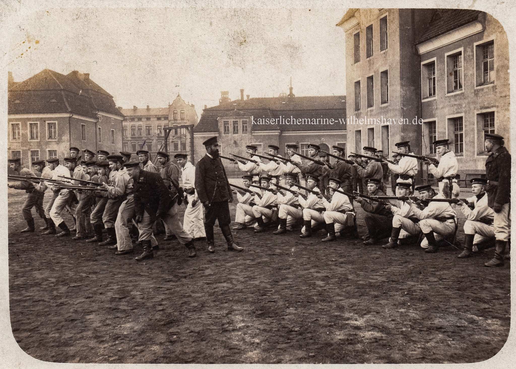 ca. 1910: Infanteristische Ausbildung von Matrosenartilleristen. Links im Bild Block "Tanga", in der Mitte das Wirtschaftsgebäude I, ganz rechts Block "Coronel". Im Hintergrund damalige Wohnbebauung an der Gökerstraße - Privataufnahme