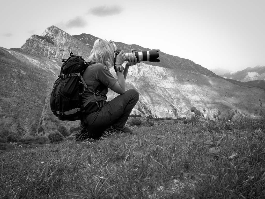 Black and white photograph of the photographer with the ‘Scudi’ of Grigna in the background