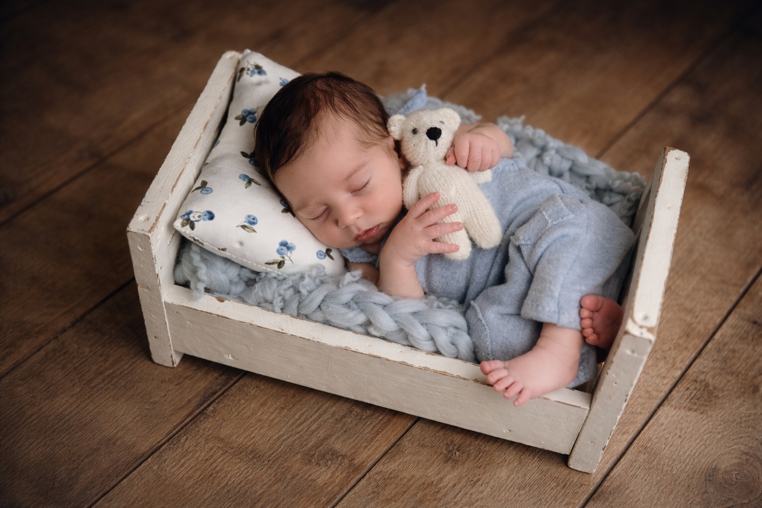 Neugeborenes schläft im Bettchen mit Teddybär – natürliche Newbornfotografie in Eschwege