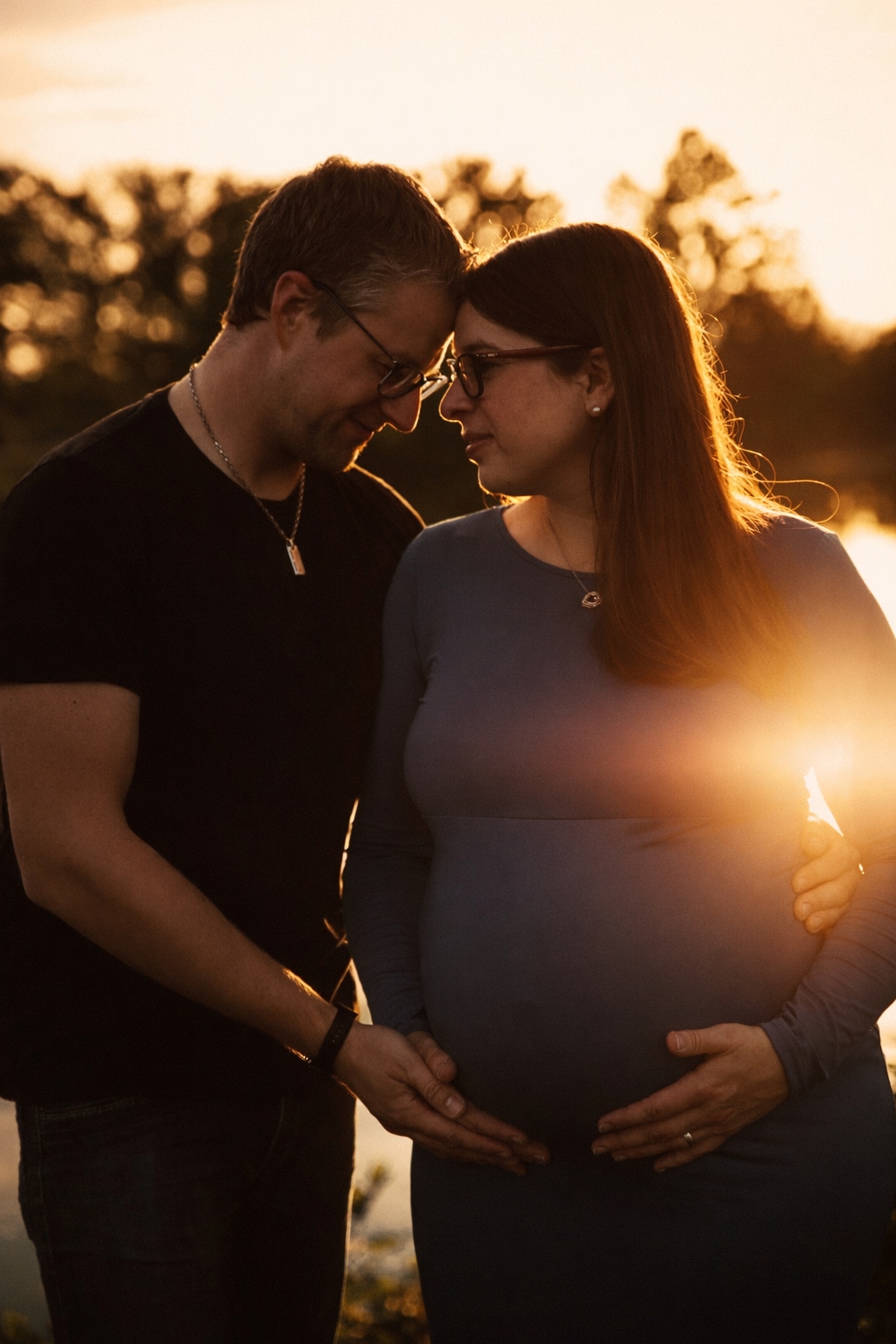 Babybauchshooting bei Sonnenuntergang am See im Werra-Meißner-Kreis – werdende Eltern mit Schwangerschaftsbauch