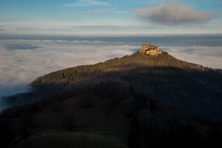 Die Burg Hohenzollern ragt aus dem Nebel heraus.