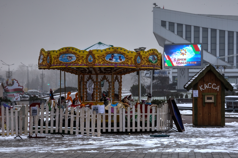 Minsk 27 – 2025, Wahlplakat im Hintergrund mit der Aufschrift: Schönen Rettungsdienst Arbeiter Tag!                      Der Tag zur ehren der Rettungsdienst Arbeiter findet jährlich am 19. Januar statt.  Minsk zwischen Weihnachten und Präsidentschaft - W
