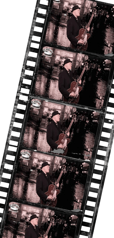 English teacher ZakWashington playing guitar in a wet West End street in the London night