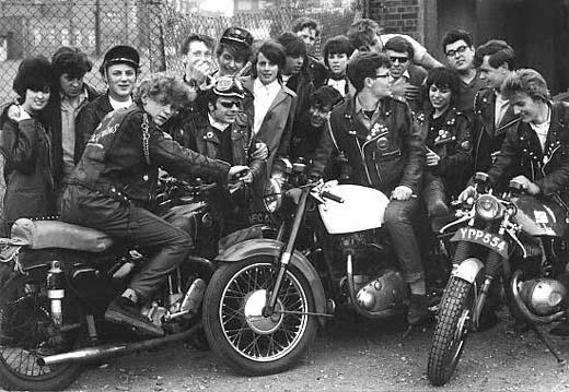 Black and white photo of a group of rockers on motorbikes with leather jackets in 1964