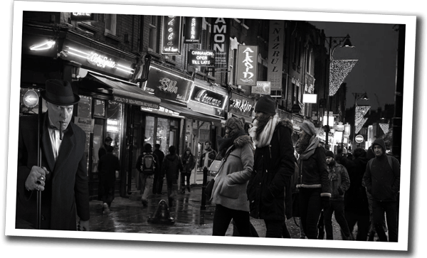 Polaroid-style photo of Chinatown, London at night filled with people and neon lights