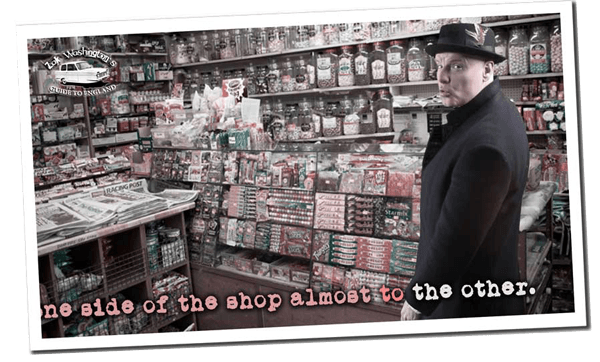 Zak in pork pie hat and crombie coat in a British sweet shop