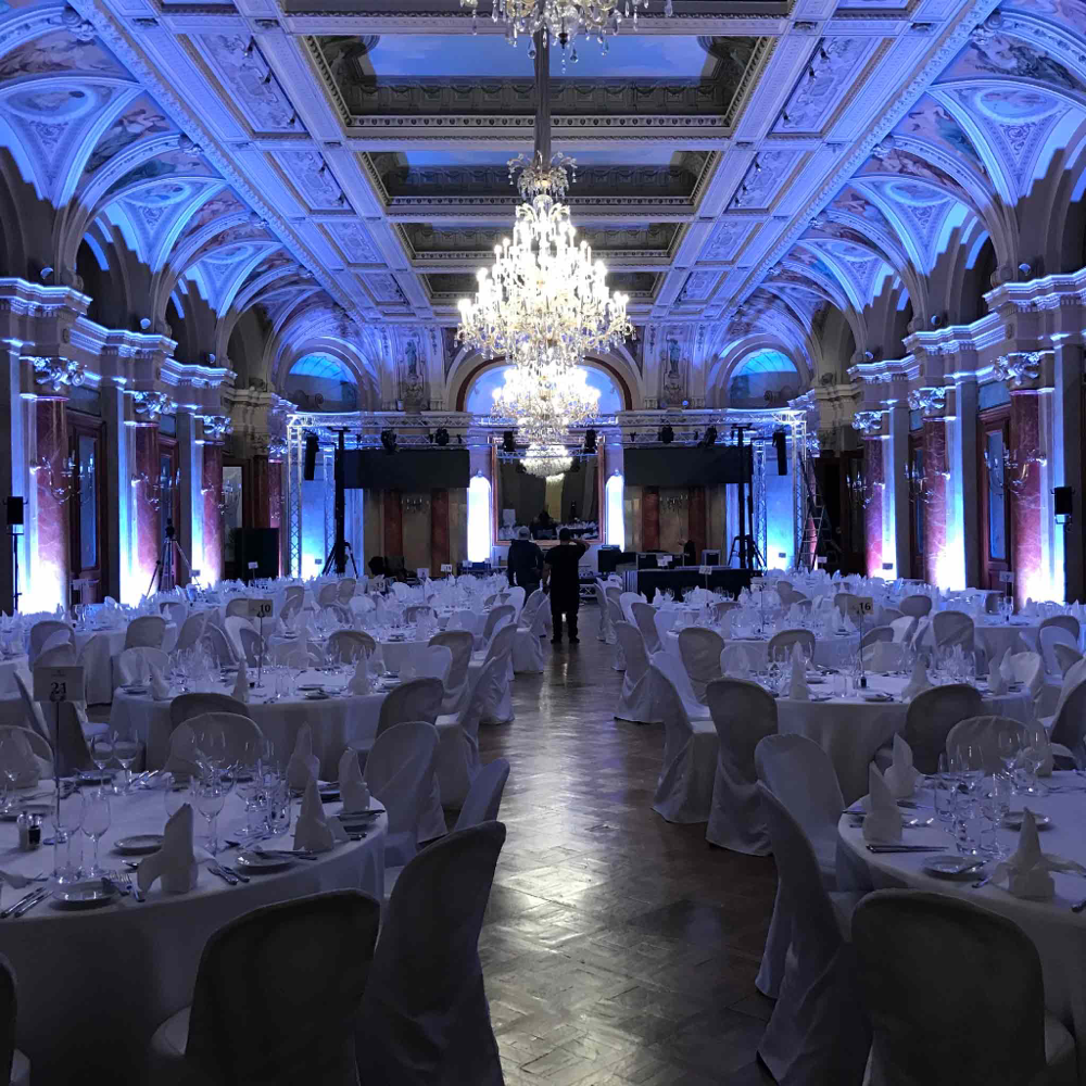 Barock Ballsaal Victoria Jungfrau Interlaken in blauem Led Licht und weiss gedeckten Tischen.