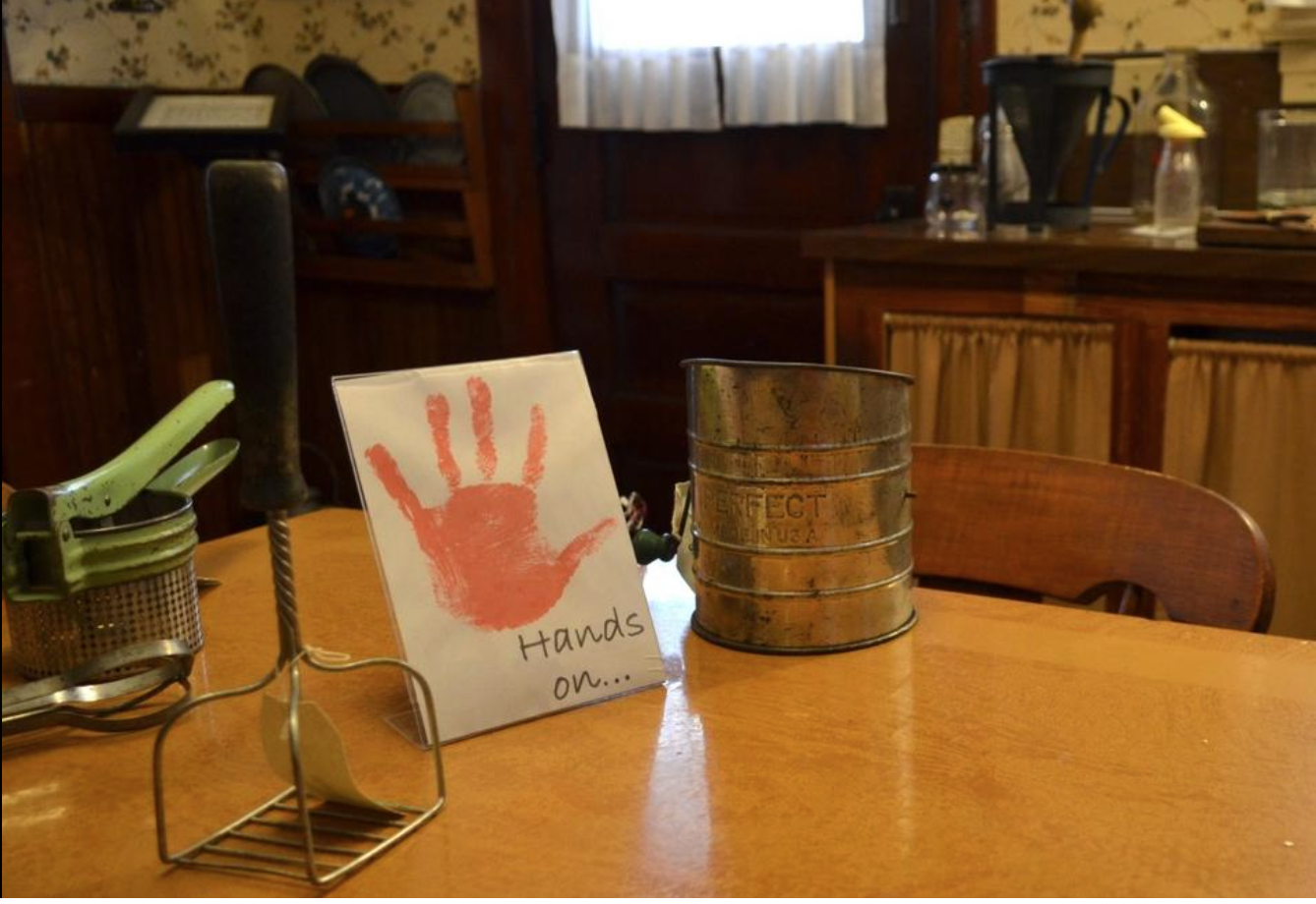 Kids who visit Zeeland's Dekker-Huis Museum are encouraged by "hands-on" signs to try out certain items, like these kitchen tools. Peg McNichol/Sentinel Staff