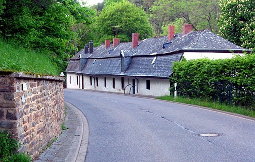 Pluwig-Hammer. Das zweigeschossige Gebäude ist so an den Hang der Straße angebaut, daß das oberer Geschoß von der Straße her zugänglich ist.