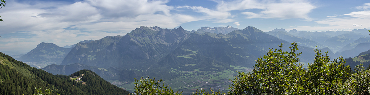 Zu Füßen liegt das Taminatal, die Aussicht geht Richtung Bündnerland über das Calanda Massiv.