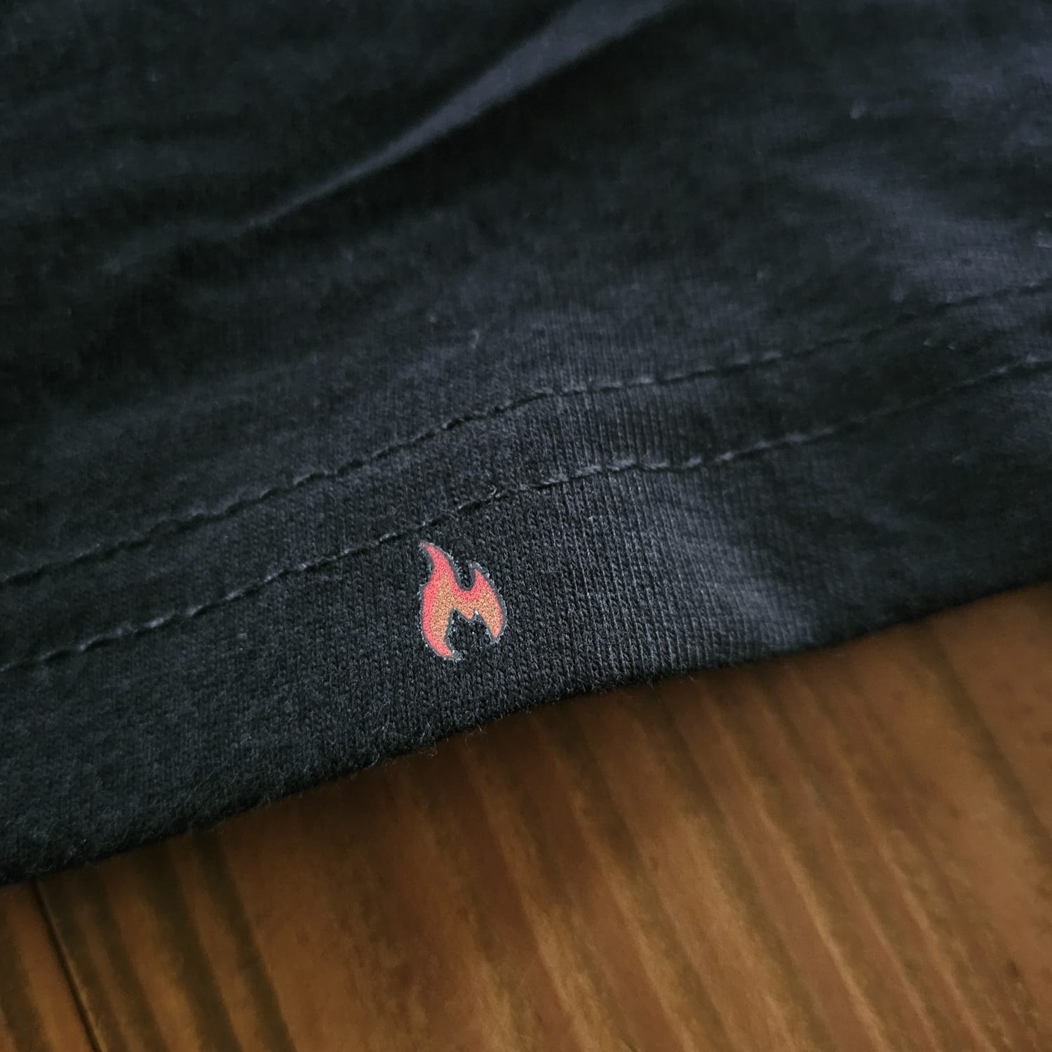 Feuerwehr T-Shirt Saum mit kleinem Flammen Logo Print. Detailansicht der hochwertigen Verarbeitung von der Manufaktur A.W.esome.