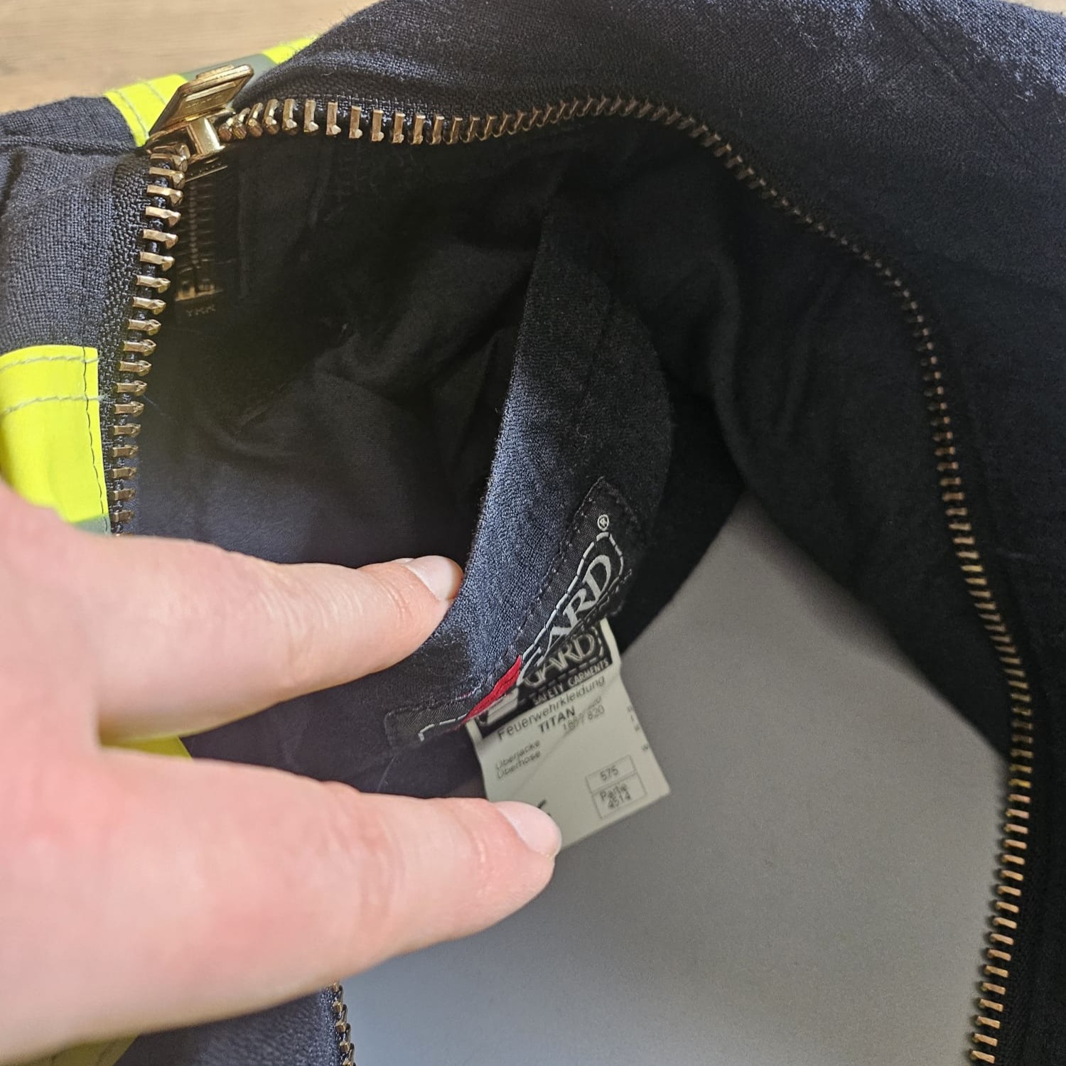 Blick in das Innenfach einer dunkelblauen Feuerwehr-Tasche mit originalem S-GARD Feuerwehrkleidung-Etikett