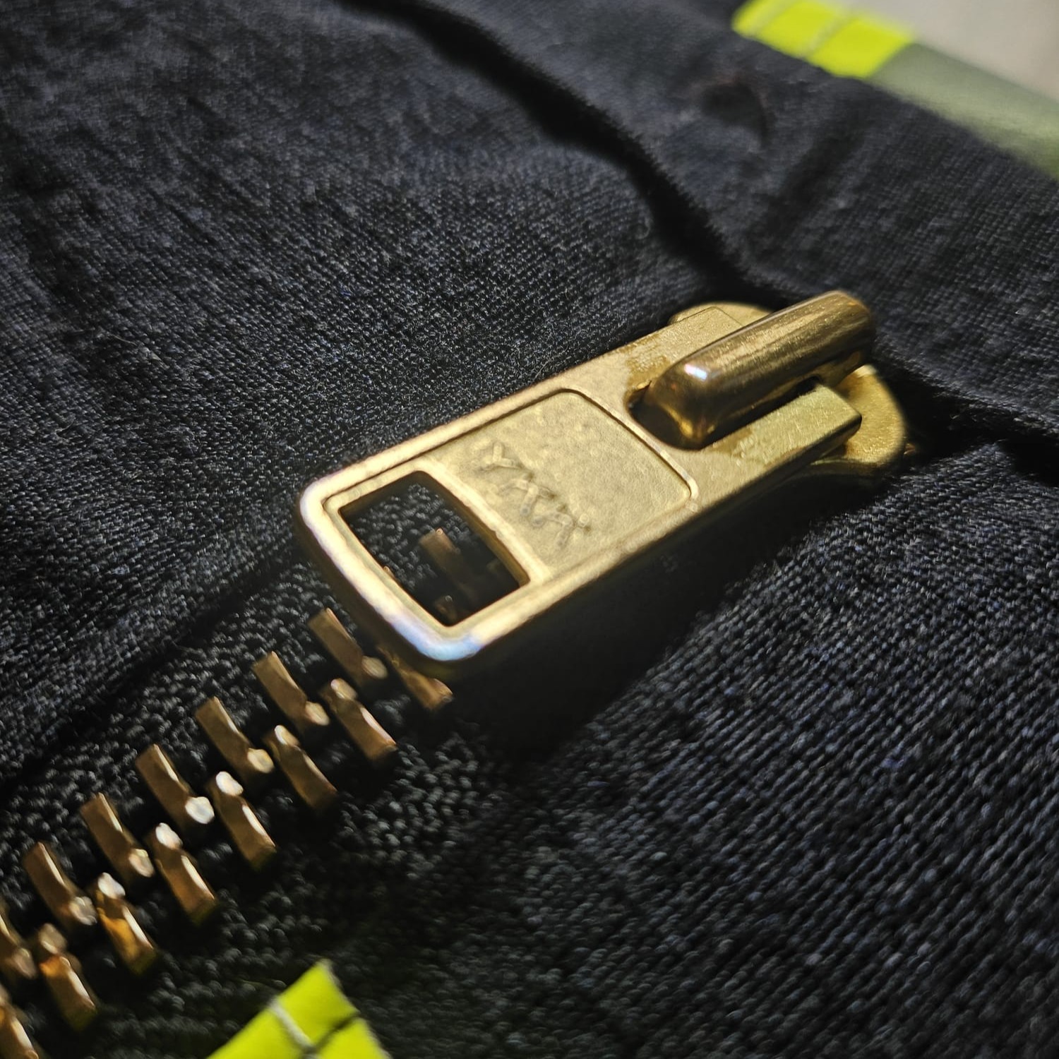 Robuster goldener YKK-Metallreißverschluss an einer dunkelblauen Feuerwehr-Tasche