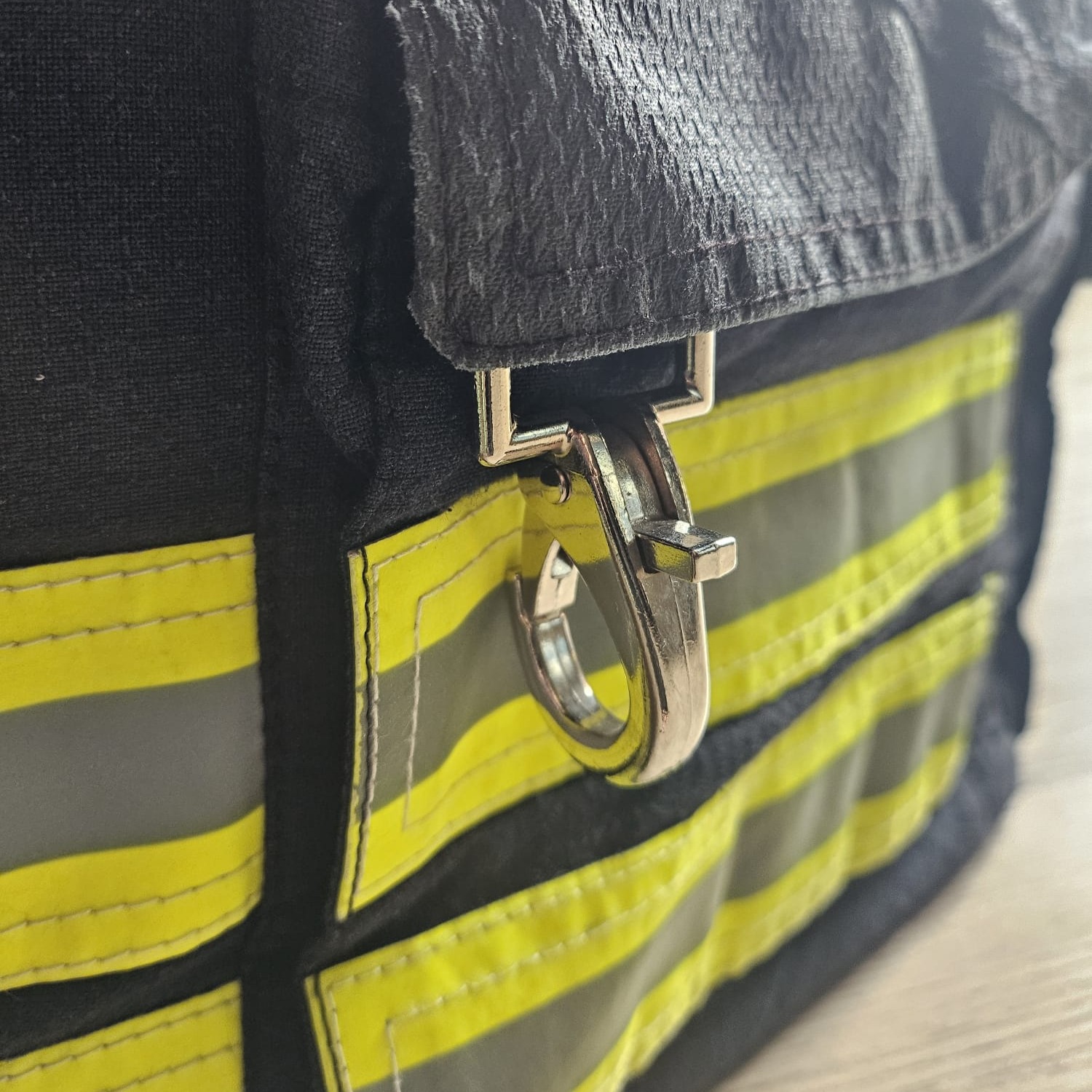 Dunkelblaue Tasche im Feuerwehr-Design mit gelb-silbernen Reflexstreifen und Karabinerverschluss,