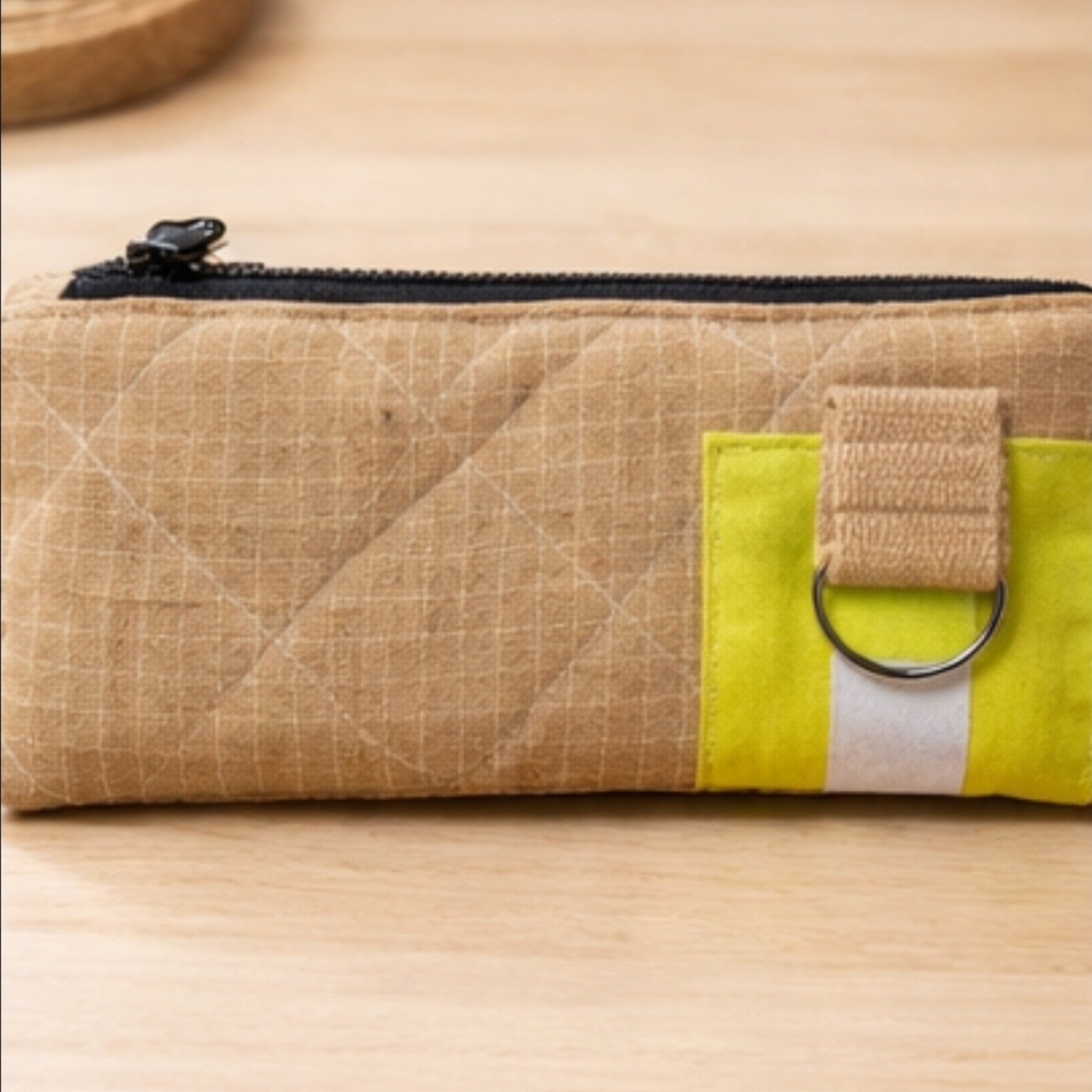 Sandfarbenes Feuerwehr-Etui mit gelbem Reflexstreifen auf Schreibtisch neben Stiften und Notizblock.
