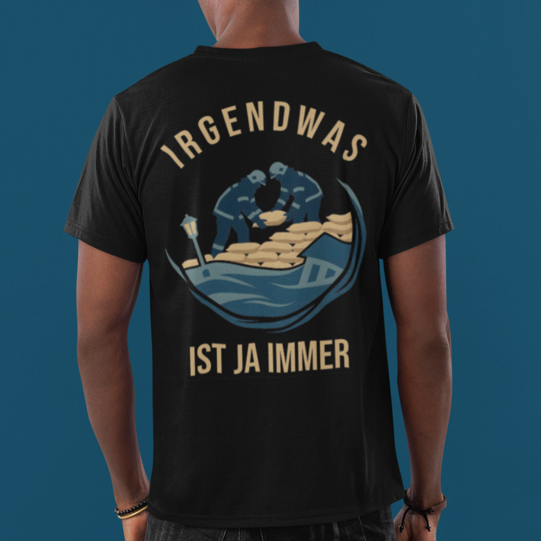 Model trägt schwarzes Feuerwehr T-Shirt mit Irgendwas ist ja immer Hochwasser Rückenprint.