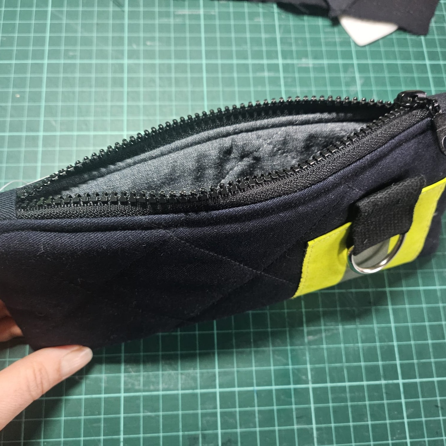 Blick in die geöffnete Upcycling Tasche aus Feuerwehrbekleidung mit grauem Innenfutter. Handgemachtes Feuerwehr Geschenk: Geöffnetes Mäppchen aus Einsatzkleidung mit Reflexstreifen.